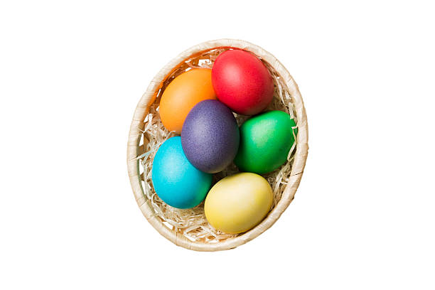 istock Basket of colorful Easter eggs isolated on white background. Easter basket filled with colored eggs top view holiday concept 2210826649