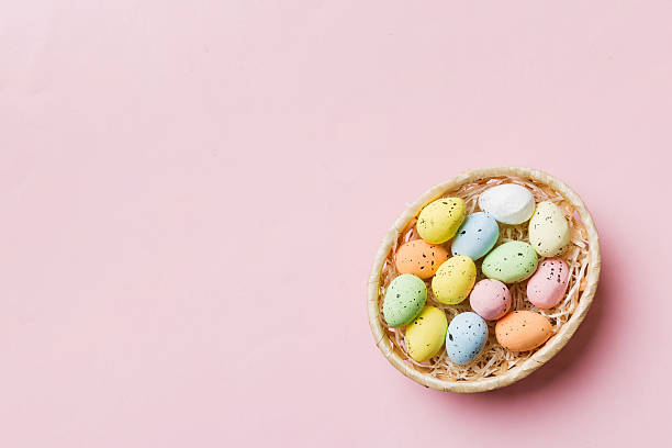 istock Colorful Easter eggs in wicker basket against colored background, closeup. top view with copy space 2210826650