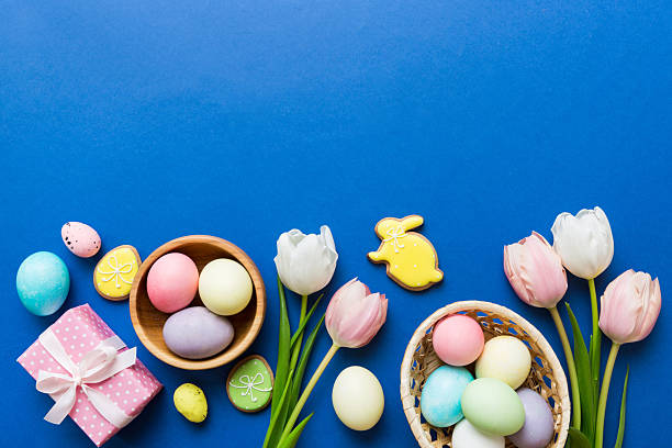 istock Easter frame with eggs, gift box and tulip on a colored background. The minimal concept. Top view Happy Easter composition. Card with a copy space of the place for the text 2210826756