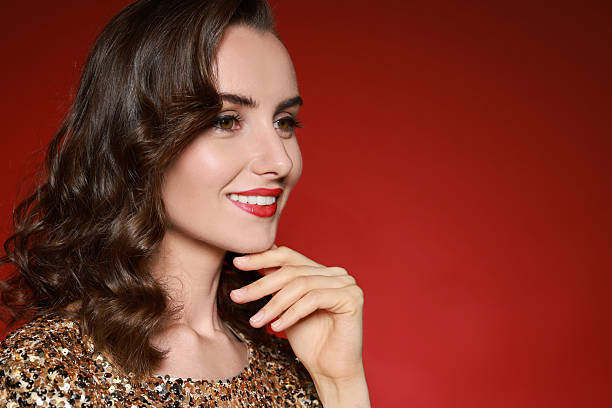 istock Smiling woman with perfect makeup on red background. Space for text 2210826981