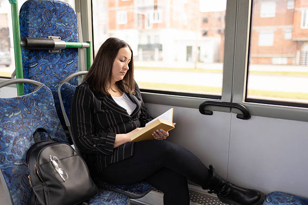 istock The woman is reading a book while riding on a bus. 2210832147