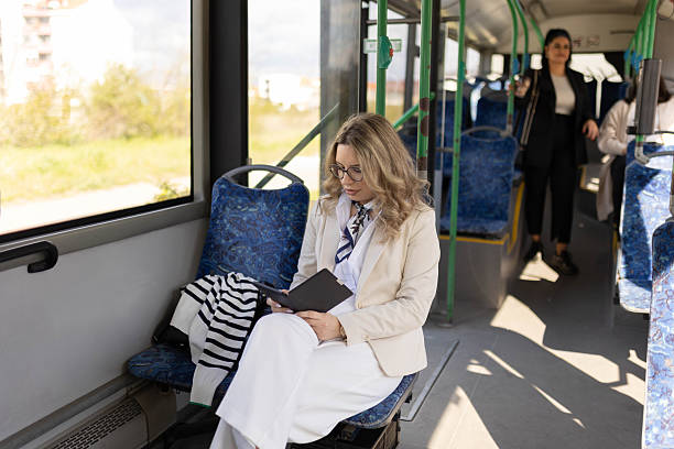 istock Woman Reading Book on Kindle During Bus Ride 2210832276