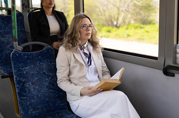 istock A woman sitting thoughtfully on a bus and reading a book. 2210832283