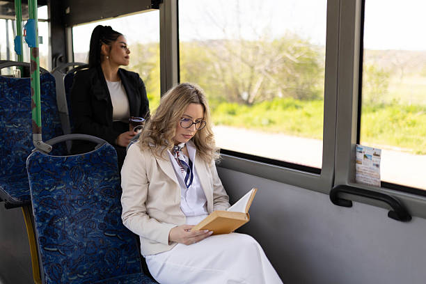 istock Women enjoy a bus ride with a beautiful view and a book. 2210832292