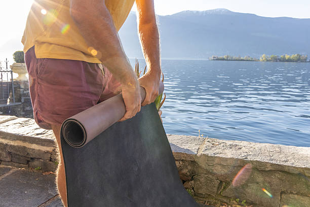 istock Man Preparing Yoga Mat by Serene Lake 2210833725