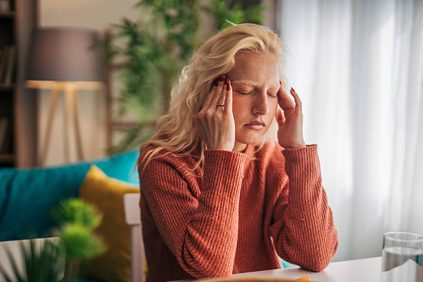istock Young woman suffering from headache at home 2210834716