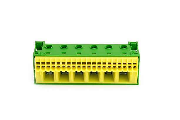 istock Electrical terminal block with green and yellow plastic housing, isolated on white background, used in industrial and electrical systems. 2210836931