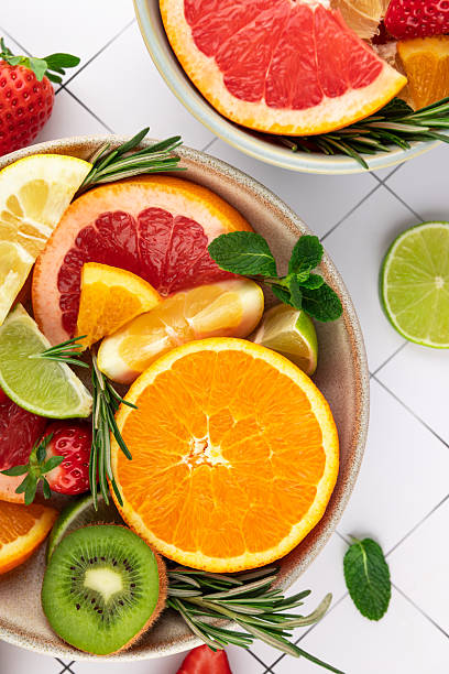 istock Vibrant fruit composition in bowls on a white tiled background. Orange, grapefruit, lime, lemon, strawberry, and kiwi. Bright colors and freshness. Concept of summer, freshness, and healthy lifestyle 2210837168