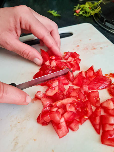 istock Close up of hands cutting tomatoes 2210839119