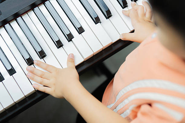 istock Close up of a little student's hands is playing, learning and practicing the piano. Music abilities for kids 2210840162