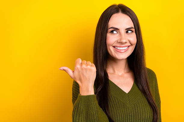 istock Photo of funky dreamy lady wear khaki pullover looking pointing thumb empty space isolated yellow color background 2210841640