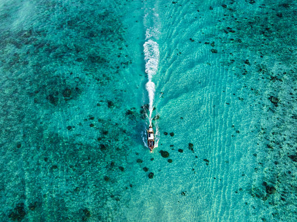 istock Boat cruising through turquoise waters with white wake trailing behind, captured from directly above in Thailand. 2210841857