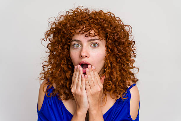 istock Surprised woman covering mouth with hands gasping 2210842669