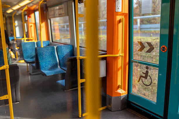 Interior view of bus with empty seats. A view of an empty subway with blue seats and yellow handrails