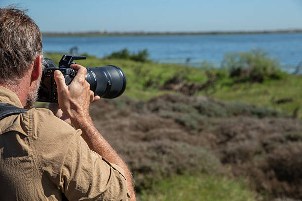 istock Birdwatcher in action capturing an image of birds 2210844208