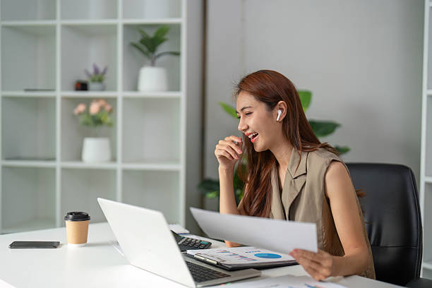 istock Work Online and Positive Engagement. A cheerful professional engages with documents and shares laughter during virtual collaboration. 2210851029
