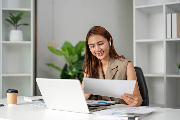 Work Online and Document Review. A young professional highlights documents with satisfaction while immersed in remote work.