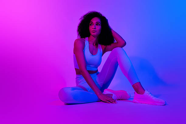 istock Full body photo of attractive sportswoman model posing sitting look visual effect empty space advert gym isolated over blue pink background 2210851778