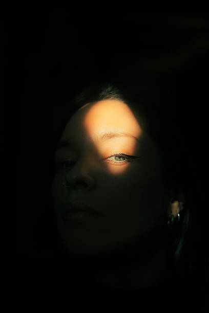 istock Artistic Portrait Shadow and Light on a Woman’s Face 2210853062
