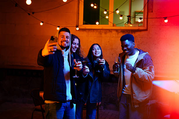 istock Friends enjoying a joyful gathering outdoors at night with drinks under string lights 2210855302