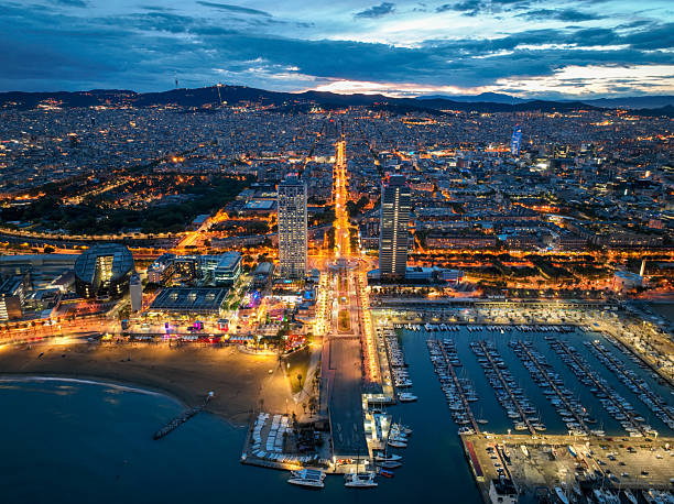 Aerial night view of Barcelona's marina entrance and beachfront lights