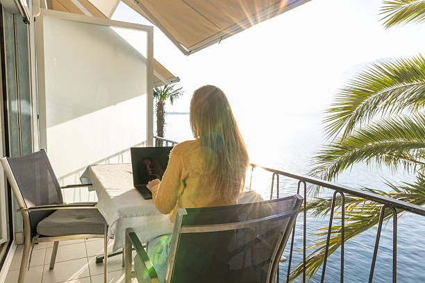 istock Woman Working on Laptop at Oceanfront Balcony with Scenic View 2210858938