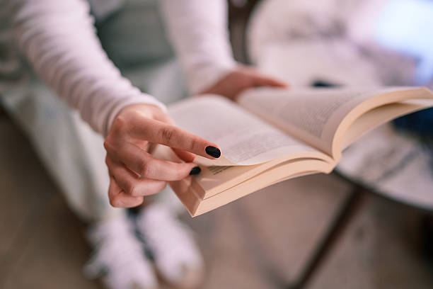 Male hand holding opened book on white background. Education concept.