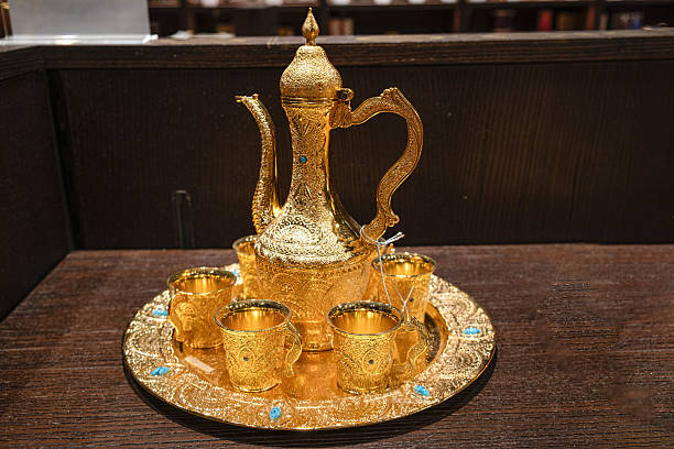 A beautifully crafted traditional teapot and two matching cups showcased on a wooden table with an artistic touch, evoking a sense of sophistication and tradition