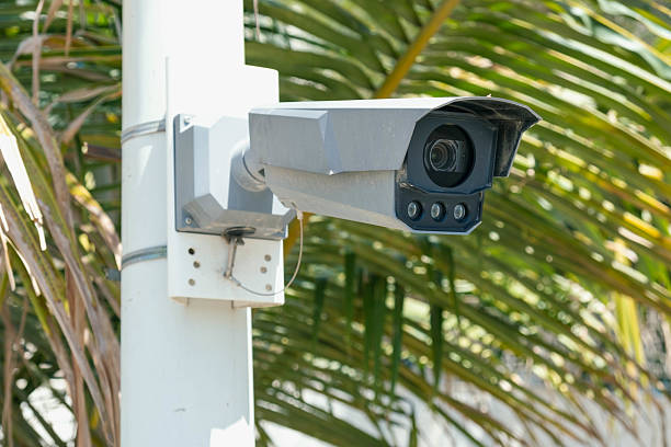 istock Security Camera Monitoring Outdoor Area in Palm Tree Setting 2210861823