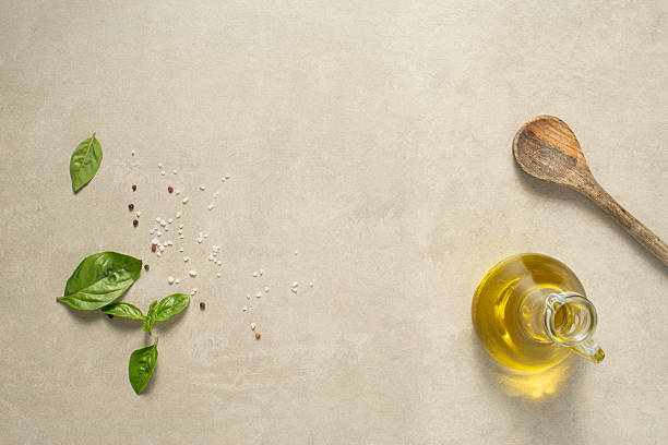 Fruit and vegetable themes: Olive oil bottle and peppermint on a cutting board ready to make vegan salad in rustic kitchen. Organic vegetables: Bell Red Peppers, carrots, lettuce, olive oil, peppermint, potatoes, onions, celery, broccoli, carrots, cucumber, Zucchini, arugula, chieves, eggplant,