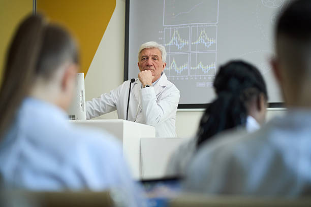 istock Elderly Scientist Giving Lecture to Diverse Group of Students 2210864991