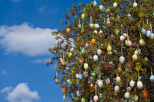 A lot of colourful easter eggs hanging at branches. Close up of mint Easter egg.