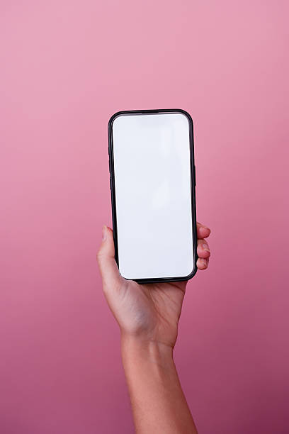 istock Woman holding smartphone with blank white screen on pink background 2210873347
