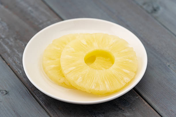 istock Sliced pineapple in syrup on a plate 2210873425
