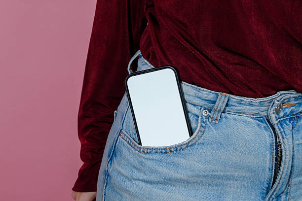 istock Woman putting smartphone with blank white screen in jeans pocket 2210874297