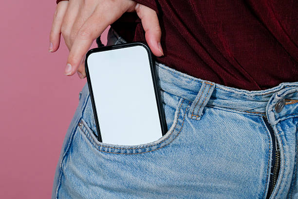 istock Woman putting smartphone with blank screen into jeans pocket 2210874349