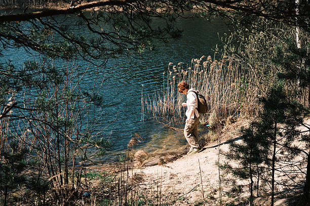 istock Mature female tourist is exploring forest lake in early spring 2210879280