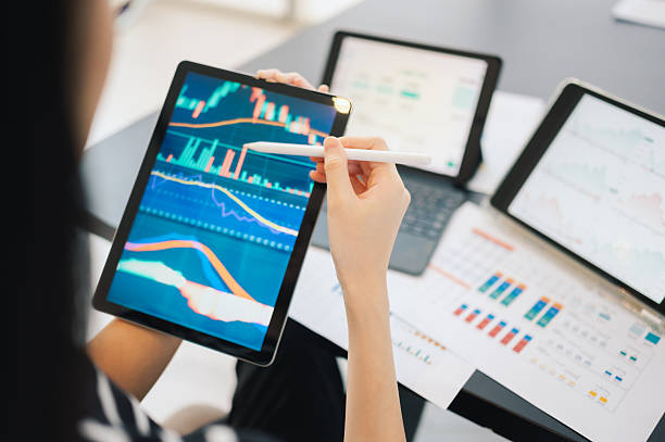 istock investor using stylus to interpret stock trend data on portable device in tech workspace analyzing real-time financial charts on tablet during high-stakes digital market 2210881215
