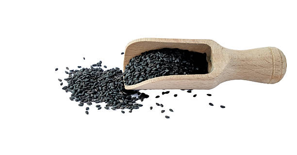 istock Black sesame seeds with wooden scoop on white background. 2210881838