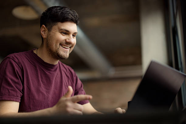 istock Smiling Man Using Laptop in an Industrial Style Workspace 2210885435