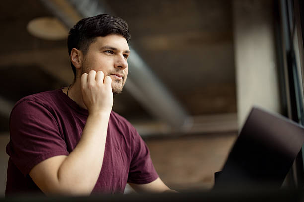 istock Focused Young Man Working on a Laptop in a Modern Office 2210885447