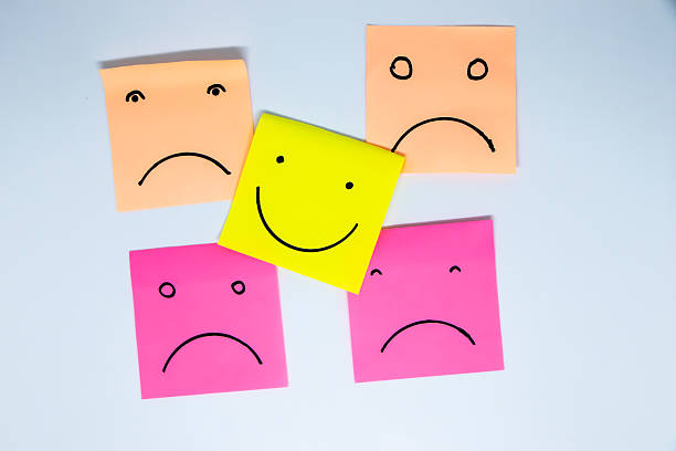 istock concept for a positive attitude with small office notes with multiple faces and one that stands out with a smile 2210887426