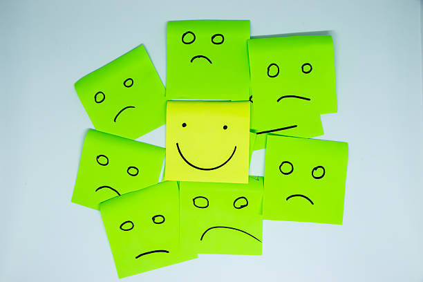istock concept for a positive attitude with small office notes with multiple faces and one that stands out with a smile 2210887427
