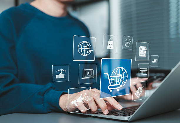 istock Online shopping and e-commerce concept. A man using laptop and phone with ecommerce icons, shopping cart, discount tag, and delivery truck, online shopping, internet retail, digital marketing, shop, 2210888788