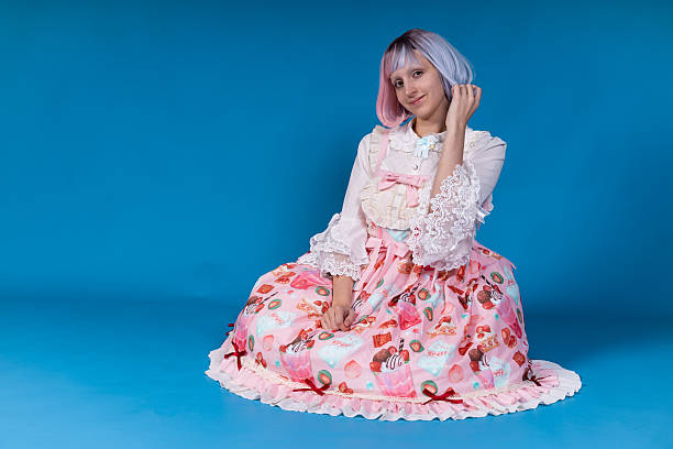 istock Young cosplayer sitting and posing on blue background 2210894335