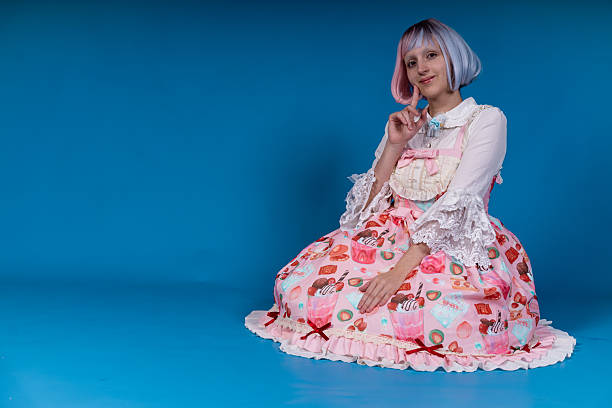 istock Young cosplayer sitting and posing on blue background 2210894376