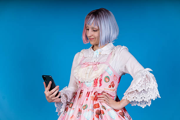 istock Young cosplayer browsing social media on smartphone in studio 2210894469