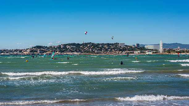 Surfers and kitesurfers in Marseille in the Provence region of southeastern France on a beautiful sunny spring day.