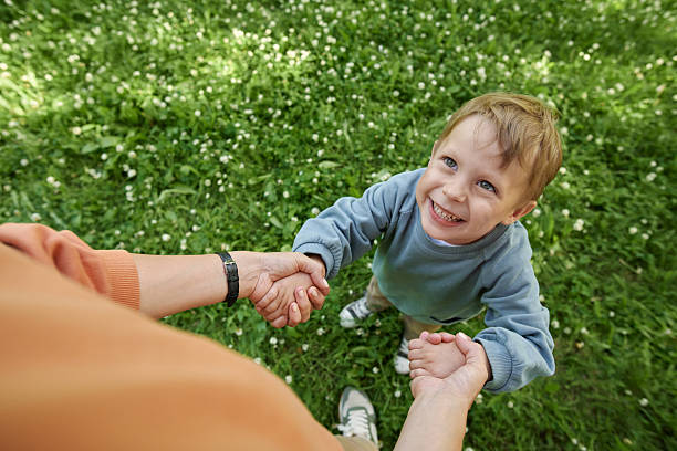 istock Smiling Boy Looking Up at Mother in Park 2210899979