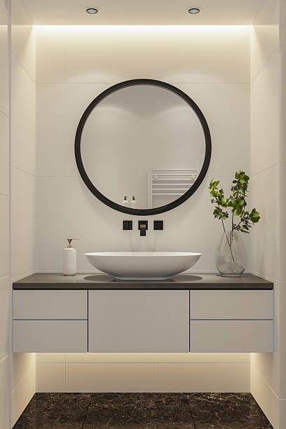 istock Modern Vanity Setup with Wall-Mounted Black Faucet and Round Mirror 2210907552